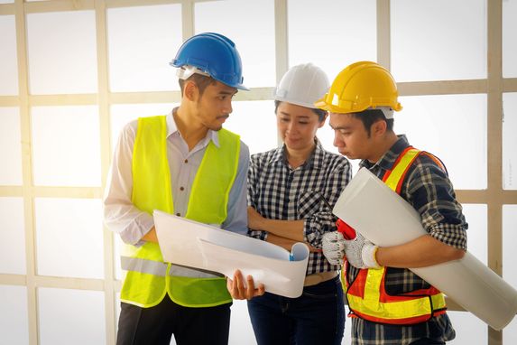 People with hardhats looking at plans